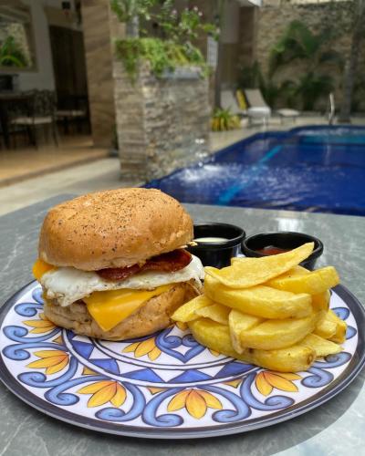 a plate with a sandwich and french fries on a table at Hotel Patrimonial by Greenfield in Guayaquil