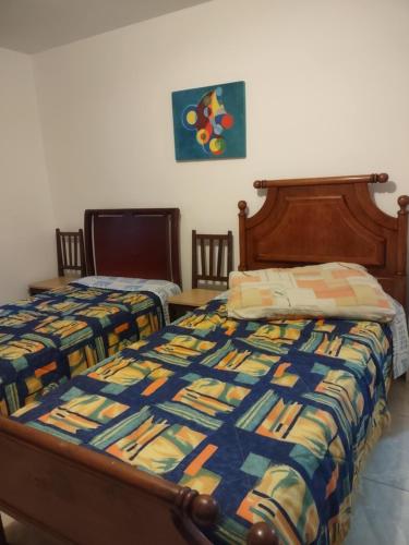 a bedroom with two twin beds with a colorful quilt at Pousada Arvoredo in Contagem