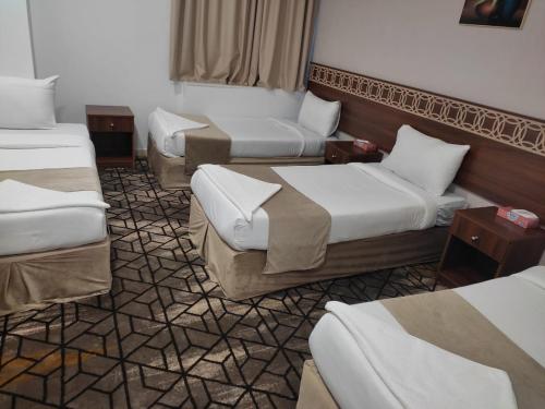 Ajyad的住宿－فندق لؤلؤة الصفا，一间酒店客房,房间内设有三张床
