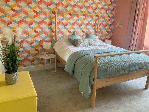 a bedroom with a bed and a geometric wall at Family friendly flat, Perfect for a Dorset escape in Bournemouth