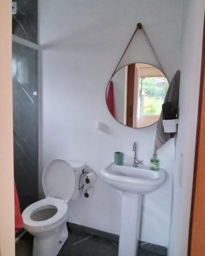 a bathroom with a toilet and a sink and a mirror at Wayak Flats PDR in Imbituba