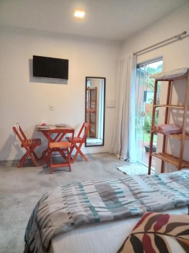 a bedroom with a bed and a table and chairs at Wayak Flats PDR in Imbituba