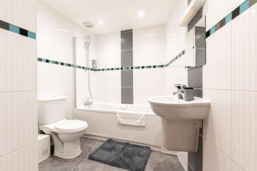 a white bathroom with a toilet and a sink at Zircon - 2 Bed Flat with Parking in Southampton