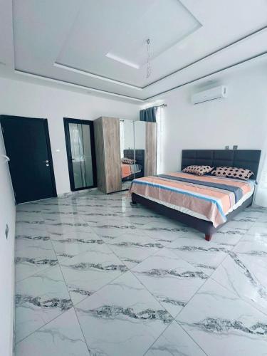 a bedroom with a bed and a large marble floor at GOP HOUSE in Madina