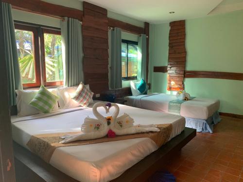 dos cisnes están sentados en dos camas en una habitación en Baan Pongam Resort en Ao Nang Beach