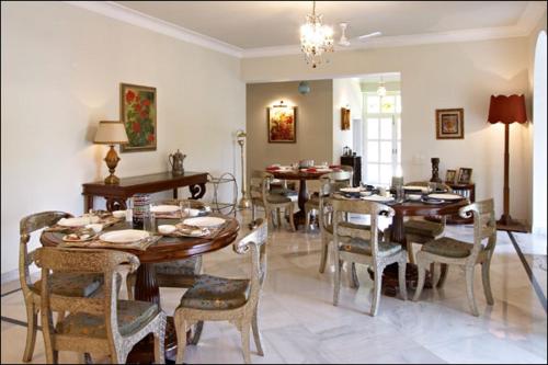 a dining room with tables and chairs in a room at Barwara Kothi in Jaipur