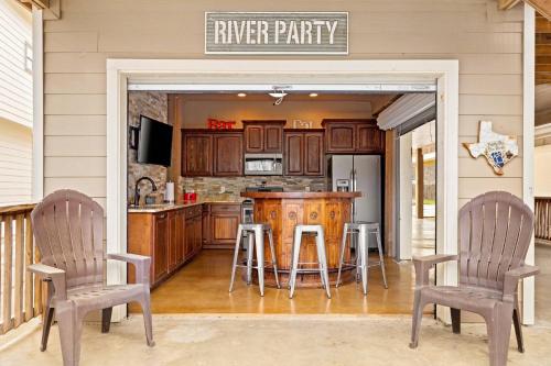 a kitchen with a counter and two chairs and a kitchen with a bar at River Road Villas #2 in New Braunfels