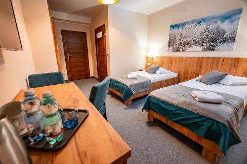 a hotel room with two beds and a table at Leśny Dworek in Łabowa