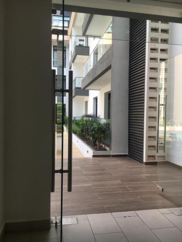 a hallway of a building with a glass door at Embassy Gardens pool view in Accra