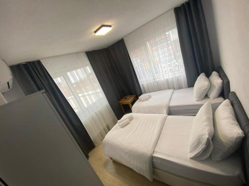 a hotel room with two beds and two windows at Safir Hotels Çorlu in Corlu