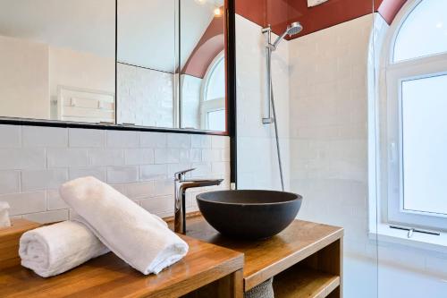 un bagno con lavandino a ciotola nera su un tavolo in legno di Maison Croix centre a Croix