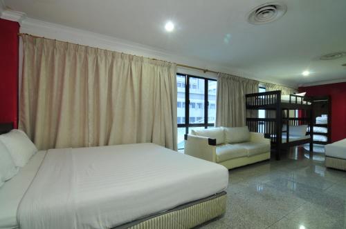 a bedroom with a bed and a couch and a chair at Hotel China Town 2 in Kuala Lumpur
