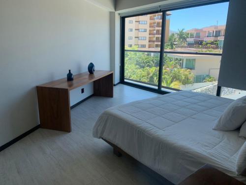ein Schlafzimmer mit einem großen Bett und einem großen Fenster in der Unterkunft Park Life Narval in Bucerías