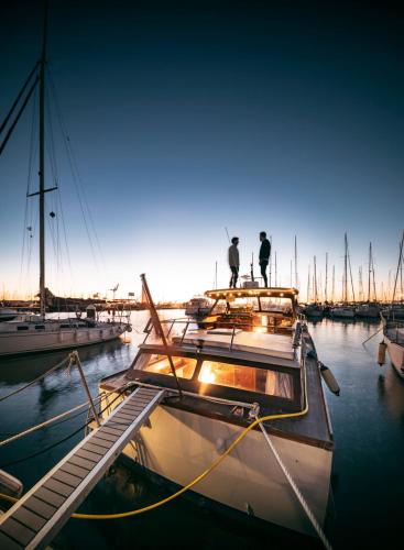 dos hombres parados en un barco en el agua en Alojamiento en Barco Oasis, en Valencia