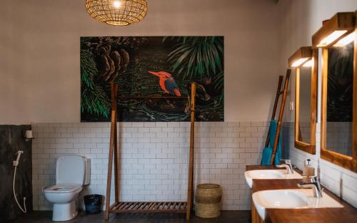 ニラヴェリにあるC Beyond Nilaveliの洗面台2つ、壁に絵画が備わるバスルーム