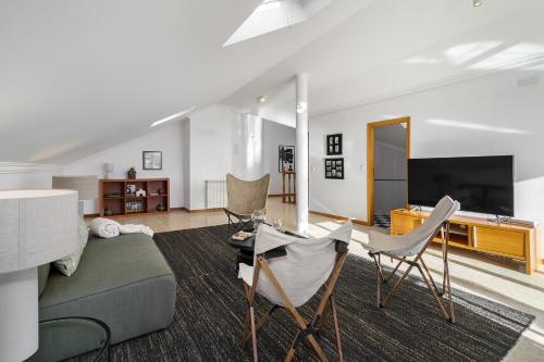a living room with a couch and chairs and a flat screen tv at WHome Surfer's Paradise Retreat: Digital Nomads & Remote Workers in Ericeira