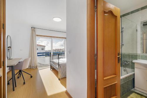 a bathroom with a desk and a sink and a shower at WHome Surfer's Paradise Retreat: Digital Nomads & Remote Workers in Ericeira