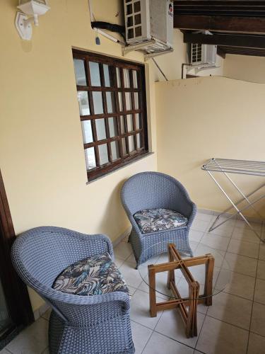 two chairs and a table in a room at Quarto particular na praia do flamengo in Salvador