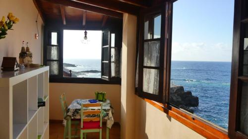 een kamer met een tafel en uitzicht op de oceaan bij Marjul in Garachico