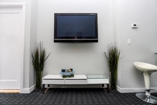 a living room with a tv on a white wall at Stylish Studio on Newbury St #3 in Boston