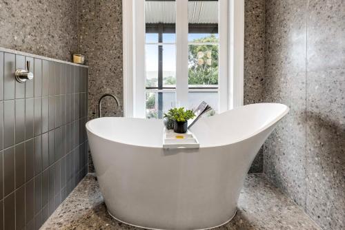 a white tub in a bathroom with a window at Gawler Park Estate in Angaston