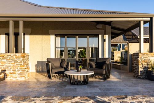 a patio with chairs and a table in front of a building at Gawler Park Estate in Angaston