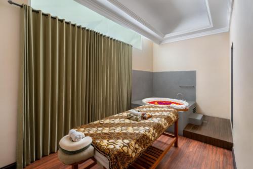 a bathroom with a tub and a bed and a shower at Maison Aurelia Sanur, Bali - By Préférence in Sanur