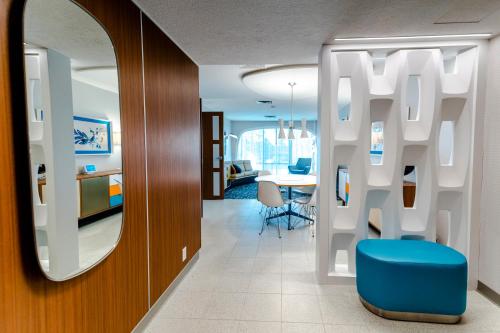 a living room with a mirror and a blue chair at Howard Johnson by Wyndham Anaheim Hotel & Water Playground in Anaheim