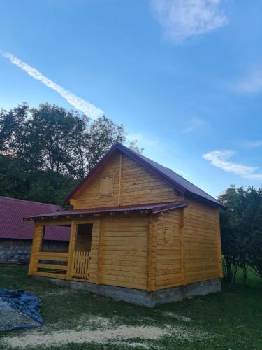 a log cabin with a fire truck behind it at Apartment Homeland in Kolašin