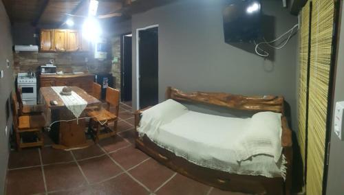 a bedroom with a bed and a table in a room at Alojamiento Tanti in Villa Santa Cruz del Lago