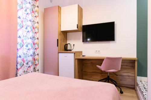 a small room with a desk and a pink chair at Partner Guest House Baseina in Kyiv