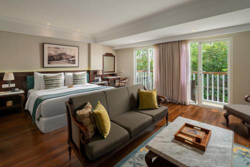 une chambre d'hôtel avec un lit et un canapé dans l'établissement Maison Aurelia Sanur, Bali - By Préférence, à anur