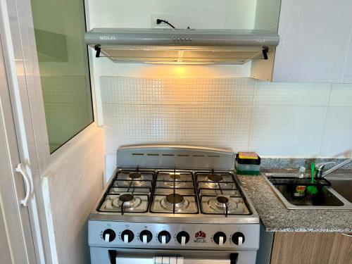 a stove in a small kitchen with a sink at Moderno Penthouse in Solorín