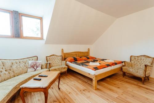 um quarto com uma cama e um sofá em Penzión Eliška em Stiavnické Bane
