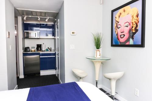 a small room with a bed and a kitchen at Cozy Newbury Street Studio, #5 in Boston