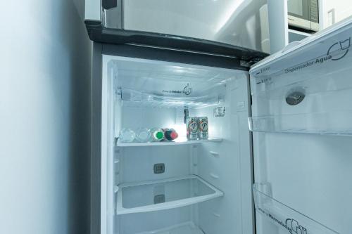 a white refrigerator with its door open in a kitchen at Soha Suites Santiago Gem Rare Find in Santiago de los Caballeros