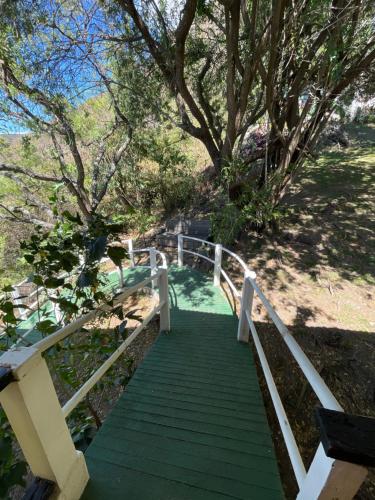 una escalera de madera con un carril blanco y árboles en Atitlan Inn, en Jucanyá