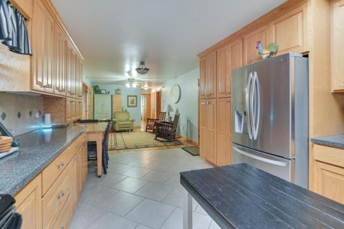 a kitchen with wooden cabinets and a stainless steel refrigerator at Large Home with Deck and Grill about 9 Mi to Virginia Tech in Christiansburg