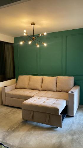 a living room with a couch and a green wall at Oasis by Franklin Hotel Boutique in Fortuna