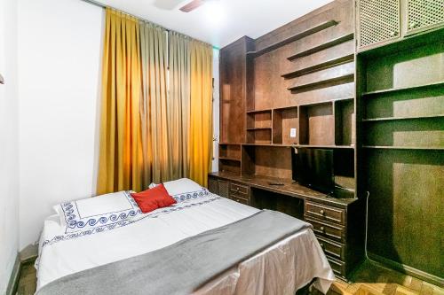 Schlafzimmer mit einem Bett und einem TV in der Unterkunft Quarto próximo da Savassi. in Belo Horizonte