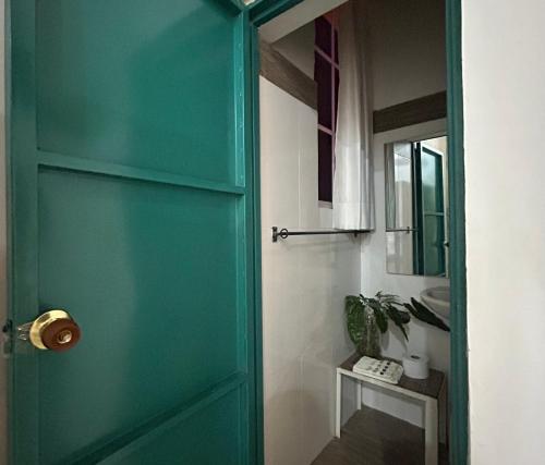 uma porta verde numa casa de banho com um lavatório em Hotel La Casa Ovalle em San Vicente de Chucurí