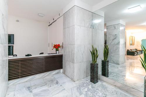 a bathroom with a shower and a tub with marble tiles at Quarto próximo da Savassi. in Belo Horizonte