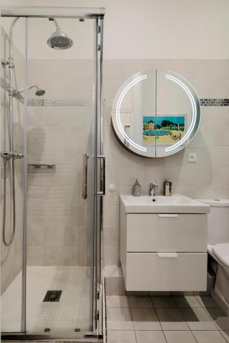 une salle de bain avec une douche, un lavabo et un miroir dans l'établissement Balyam Suites Montorgueil - Sentier, à Paris