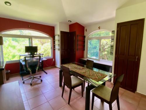 a dining room with a glass table and chairs at Magnolias Jardin & Boutique Suites in León