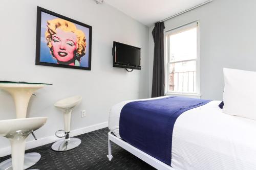 a bedroom with a bed and a tv on the wall at Cozy & Stylish Newbury Street Studio, #9 in Boston
