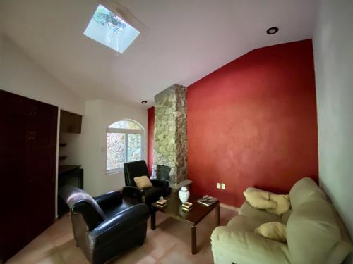 ein Wohnzimmer mit einem Sofa und einer roten Wand in der Unterkunft Magnolias Jardin & Boutique Suites in León