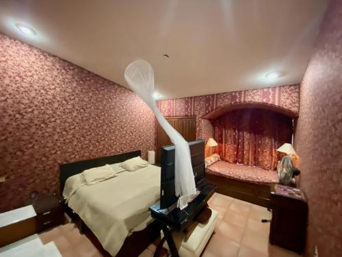 Magnolias Jardin & Boutique Suites في ليون: غرفة نوم فيها سرير وتلفزيون