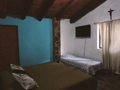 a bedroom with two beds and a tv and a window at El Cielo 