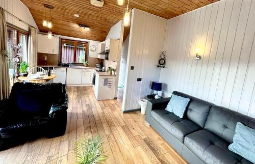 uma sala de estar com um sofá e uma cozinha em Holly Lodge 12 Hot Tub em York