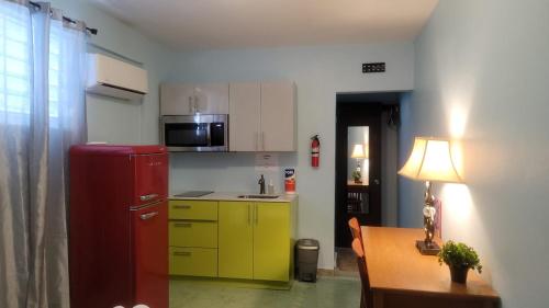 a kitchen with a red and yellow refrigerator and a table at Private Studio near Beach and Restaurants with AC, Unit 3 in San Juan